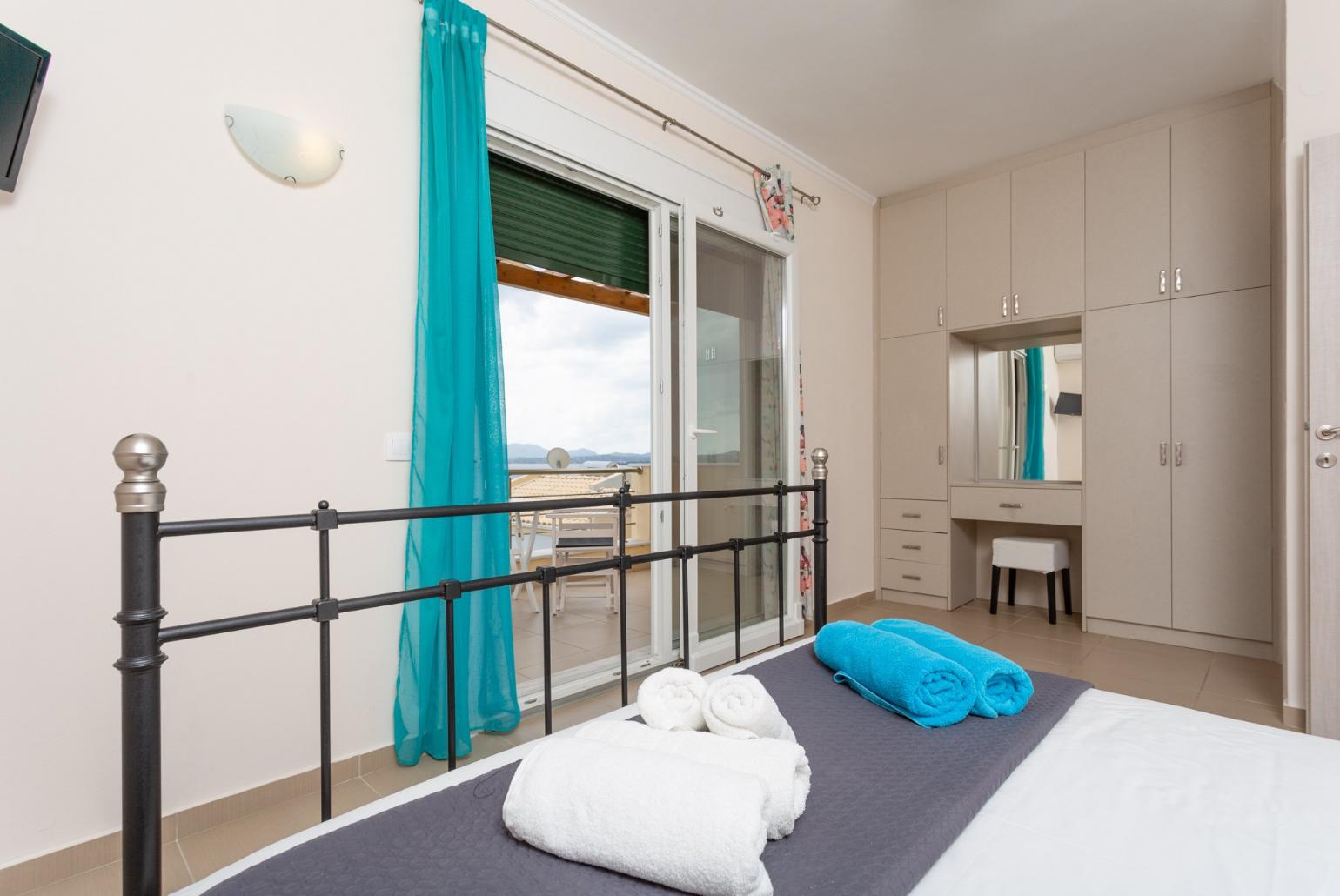 Double bedroom with en suite bathroom, A/C, TV, and balcony access with sea views