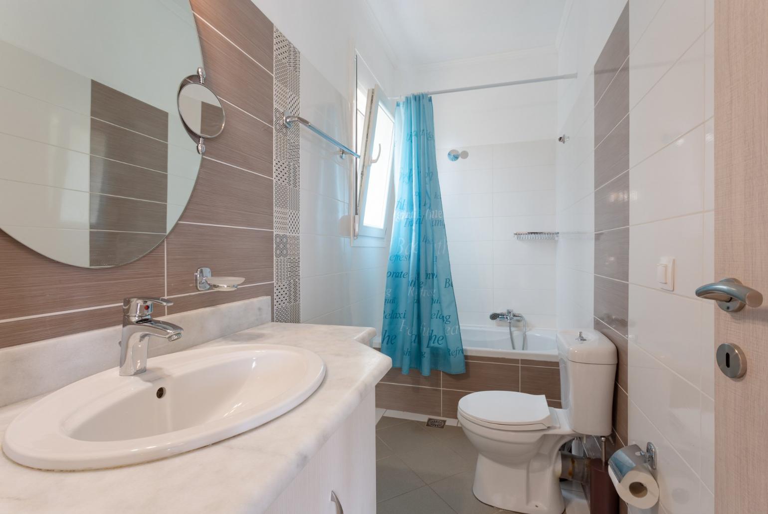 En suite bathroom with bath and overhead shower