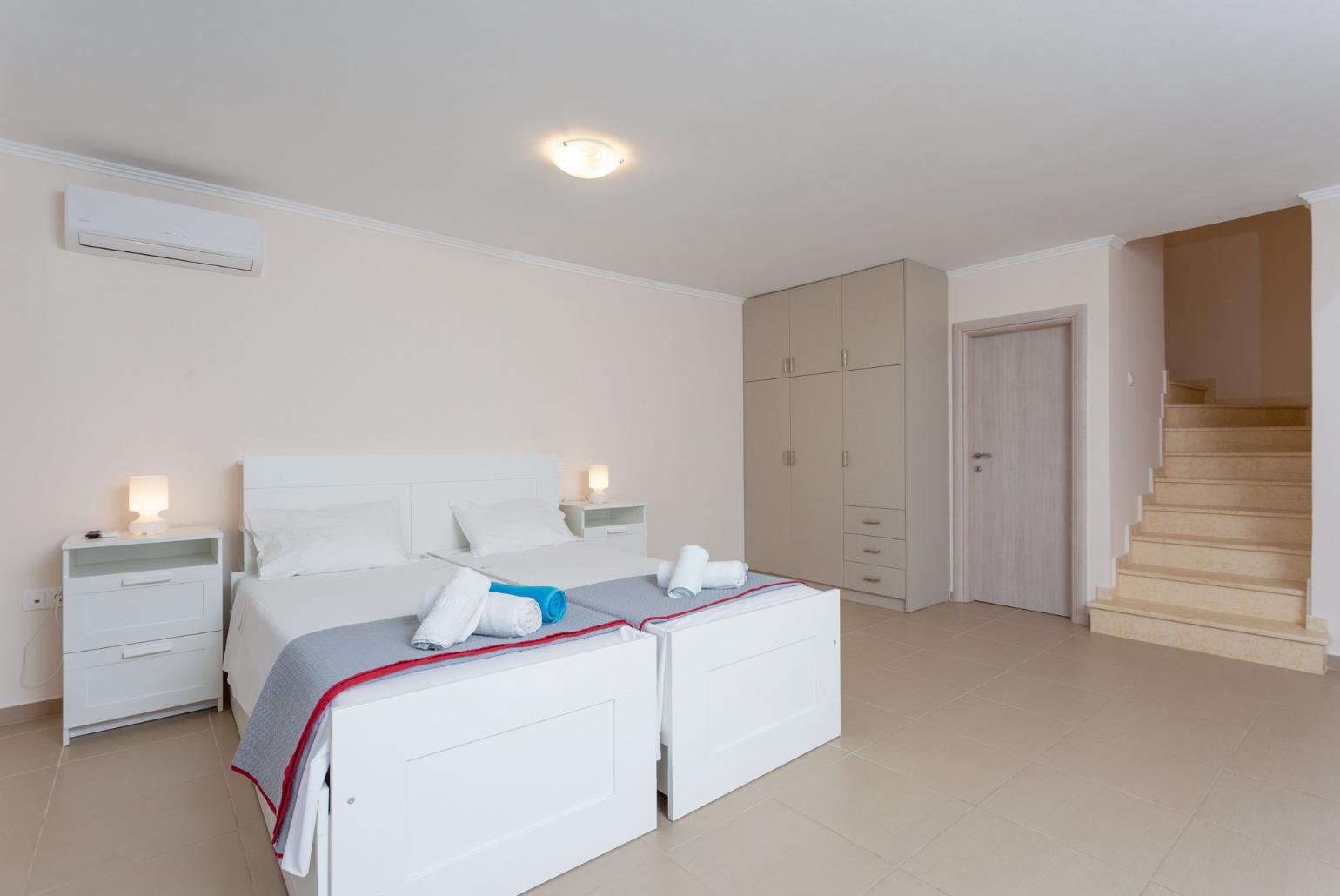 Twin bedroom with en suite bathroom, A/C, TV, and pool terrace access