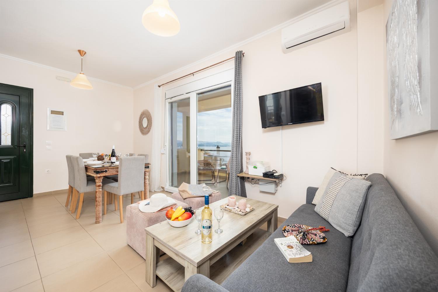 Open-plan living room with sofa, dining area, kitchen, A/C, WiFi internet, satellite TV, and sea views