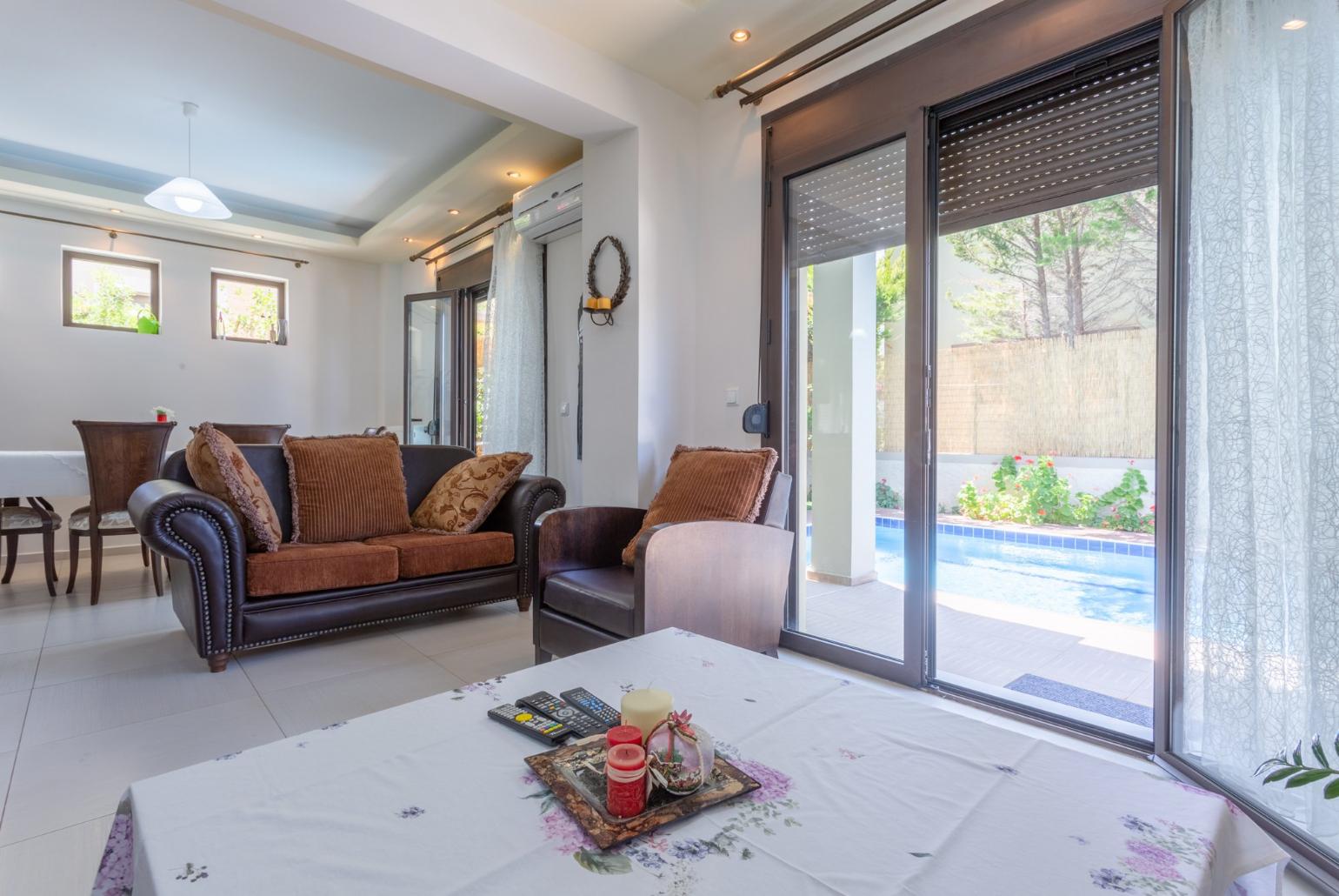 Open-plan living room with dining area, kitchen, A/C, WiFi Internet, Satellite TV, and pool terrace access