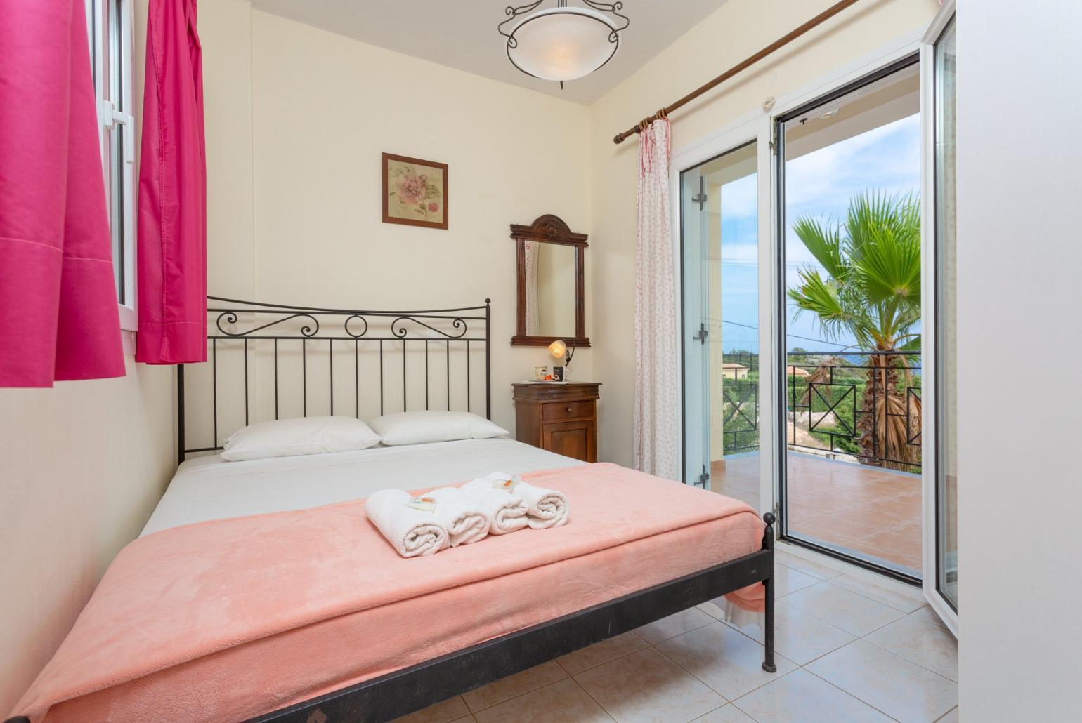 Double bedroom on first floor with en suite bathroom, A/C, and balcony access with sea views
