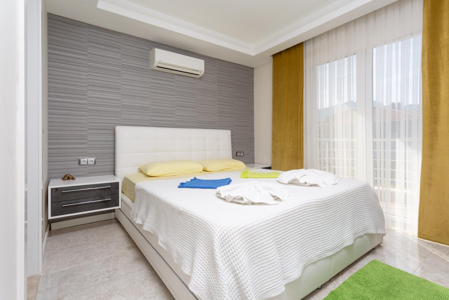 Double bedroom with en suite bathroom, A/C, TV, and balcony access