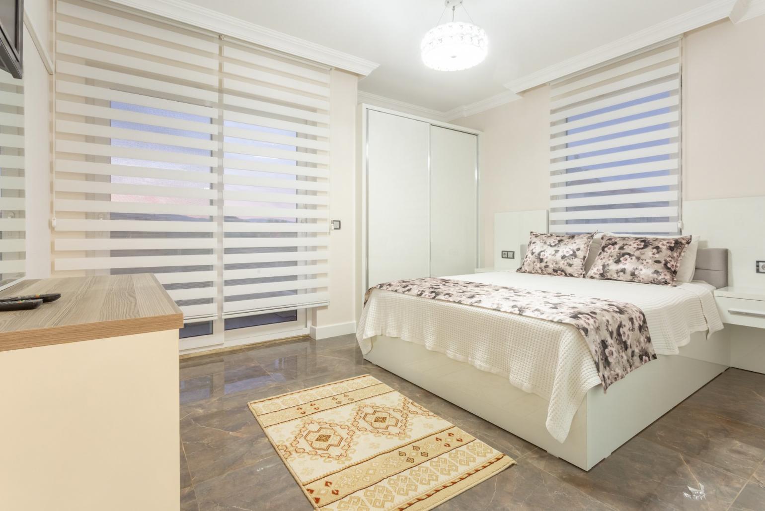 Double bedroom with en suite bathroom, A/C, TV, and balcony access