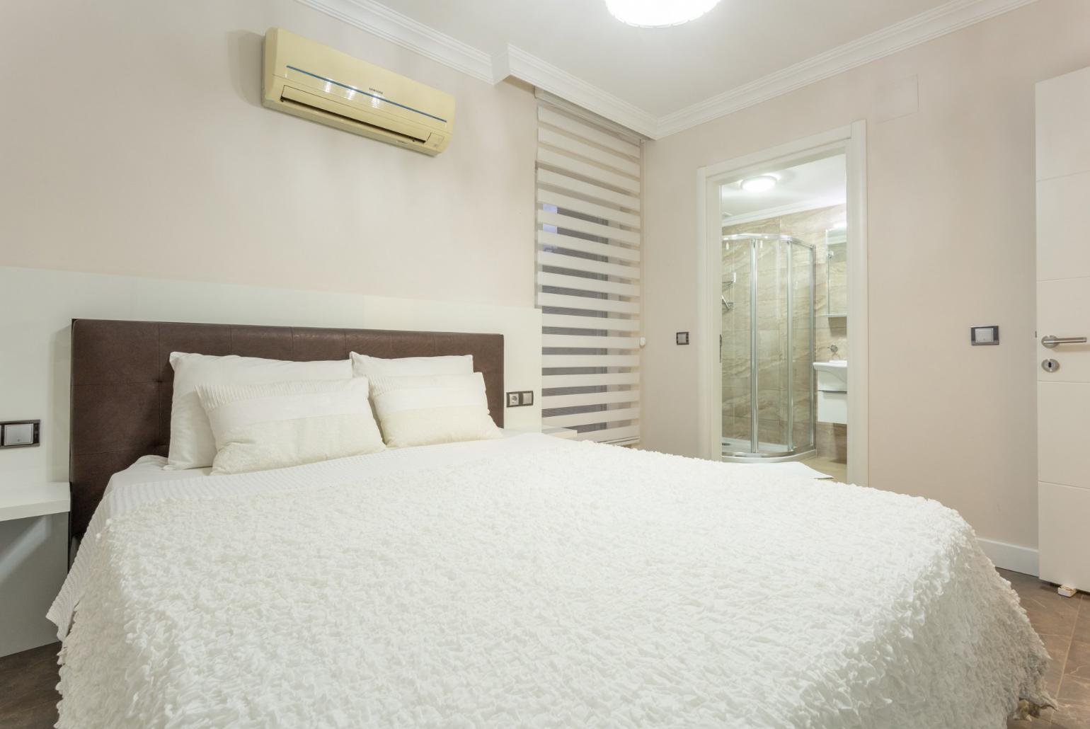 Double bedroom with en suite bathroom, A/C, and balcony access