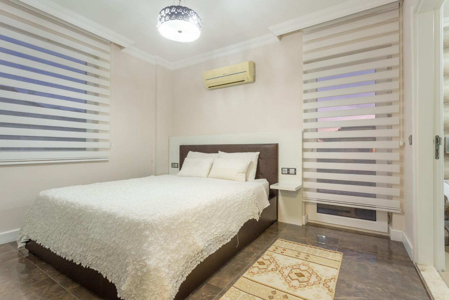 Double bedroom with en suite bathroom, A/C, and balcony access