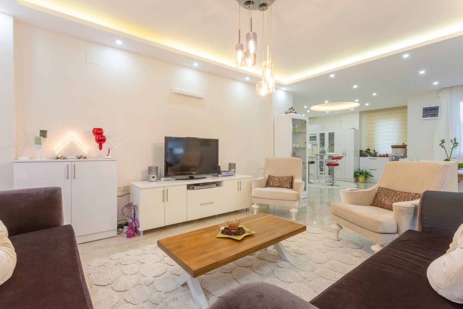 Open-plan living room with sofas, dining area, kitchen, A/C, WiFi internet, satellite TV, DVD player, and pool terrace access
