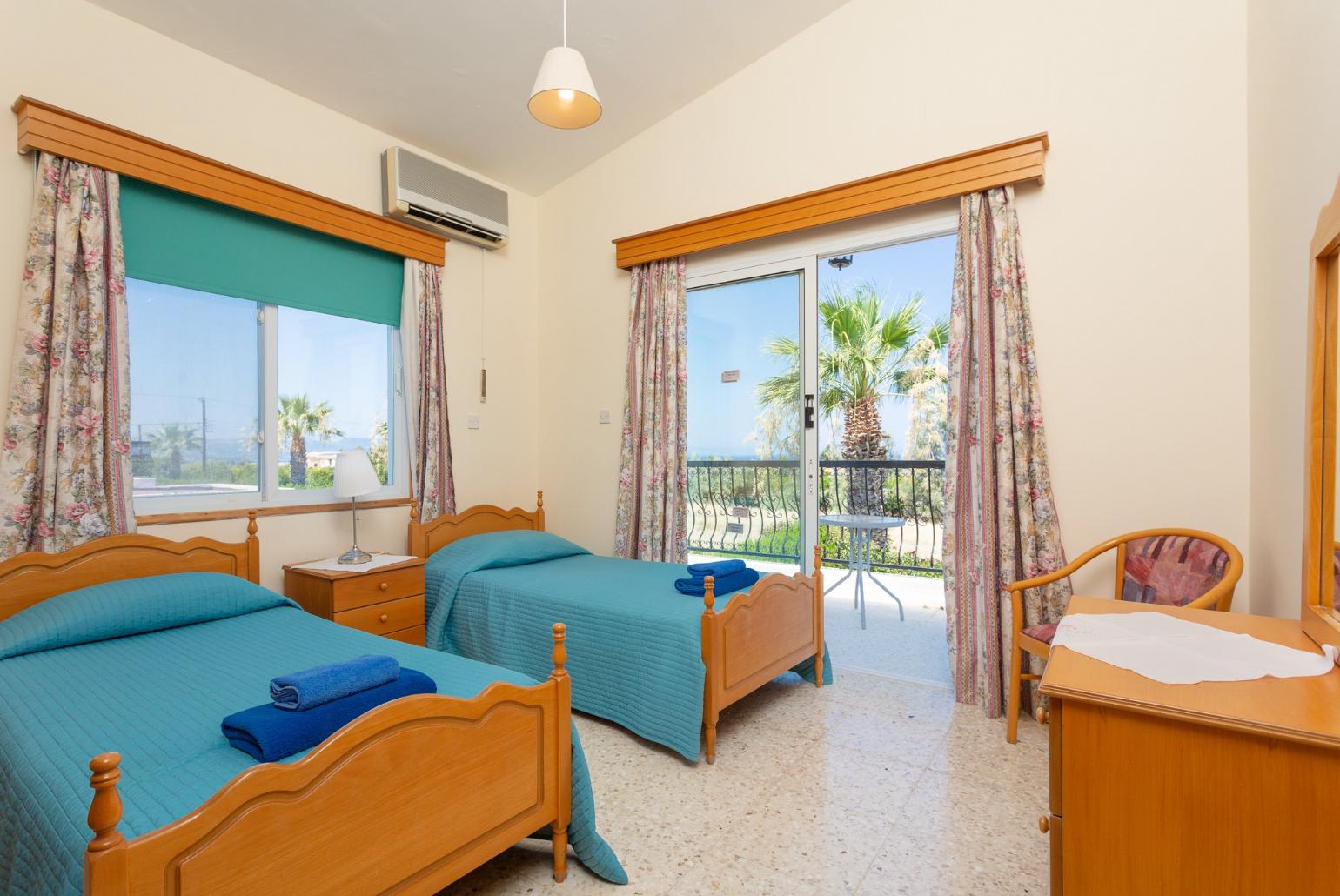 Twin bedroom with A/C, en suite bathroom, and balcony access with sea views