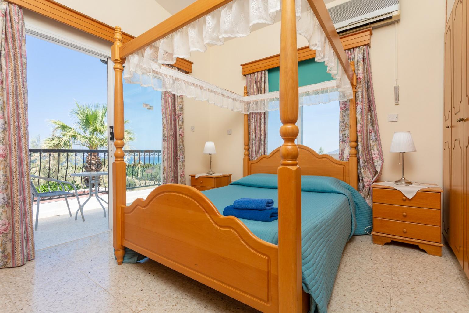 Double bedroom with A/C, en suite bathroom, and balcony access with sea views