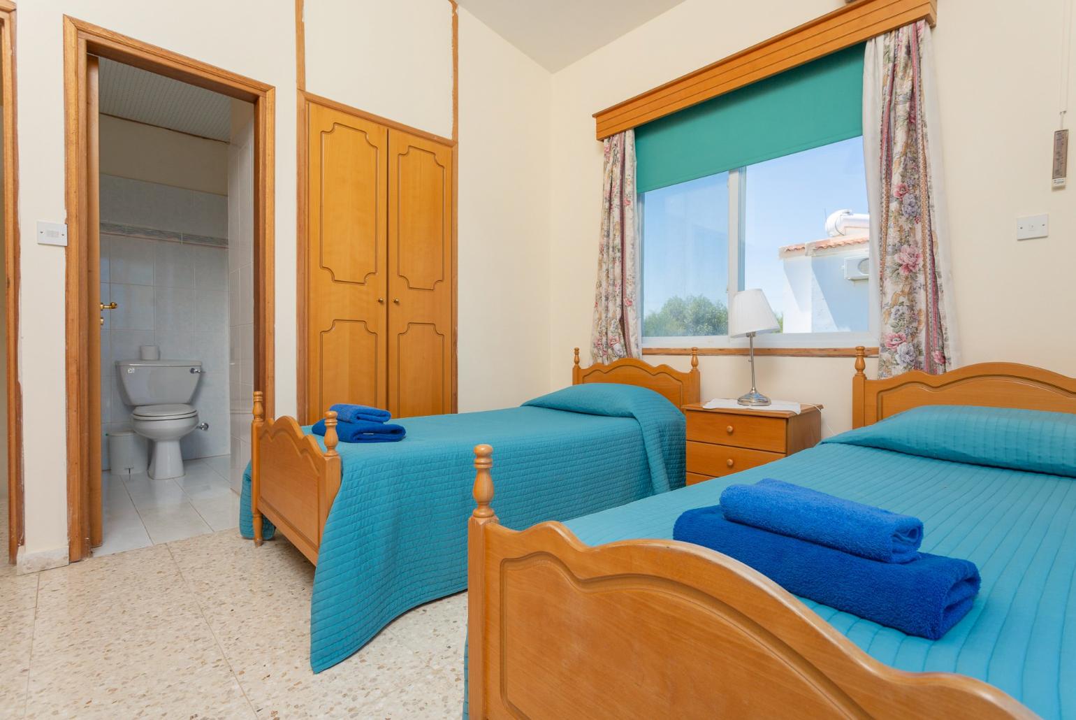 Twin bedroom with A/C, en suite bathroom, and balcony access with sea views