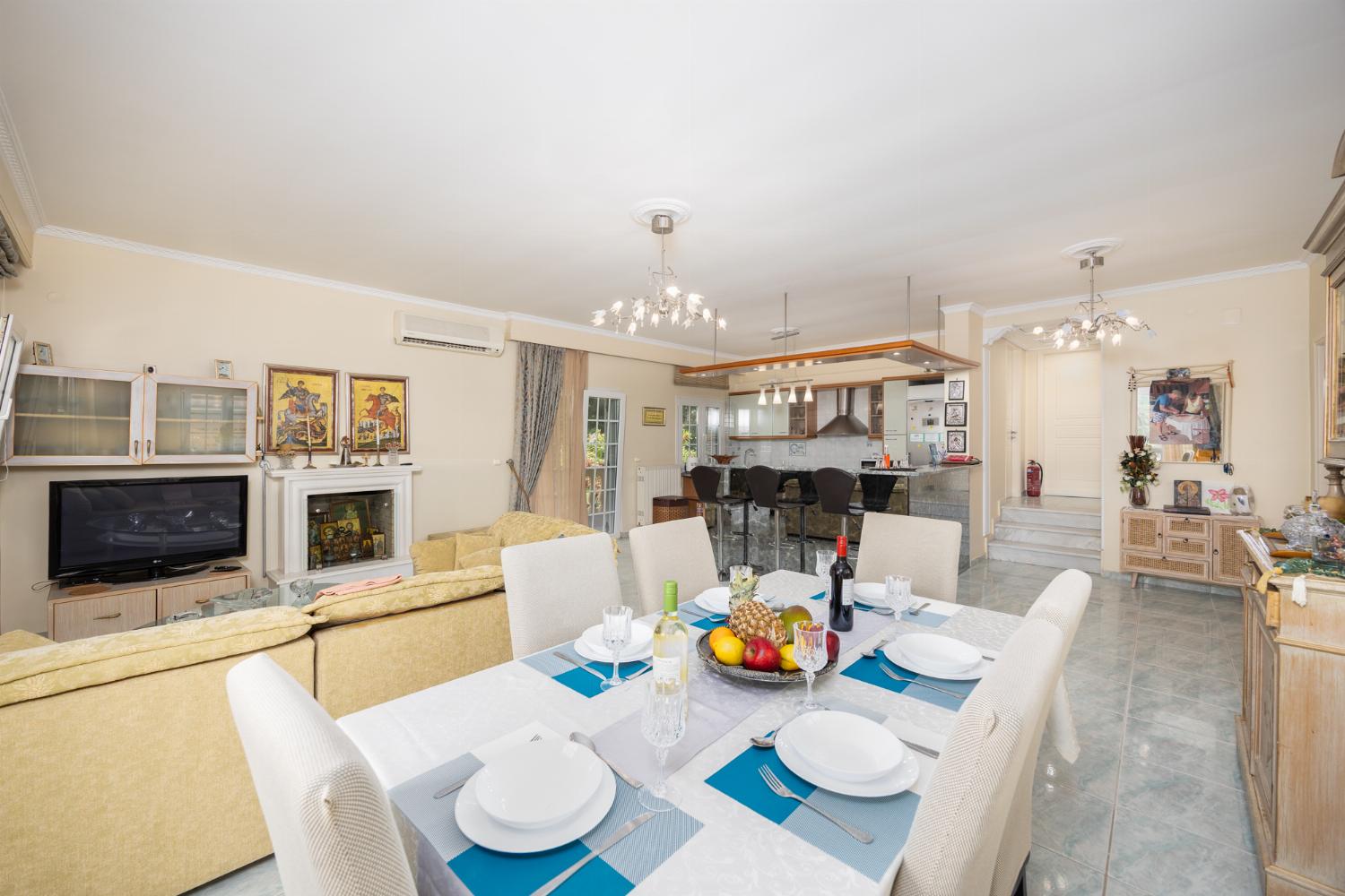 Open-plan living room with sofa, dining area, kitchen, ornamental fireplace, A/C, WiFi internet, and satellite TV