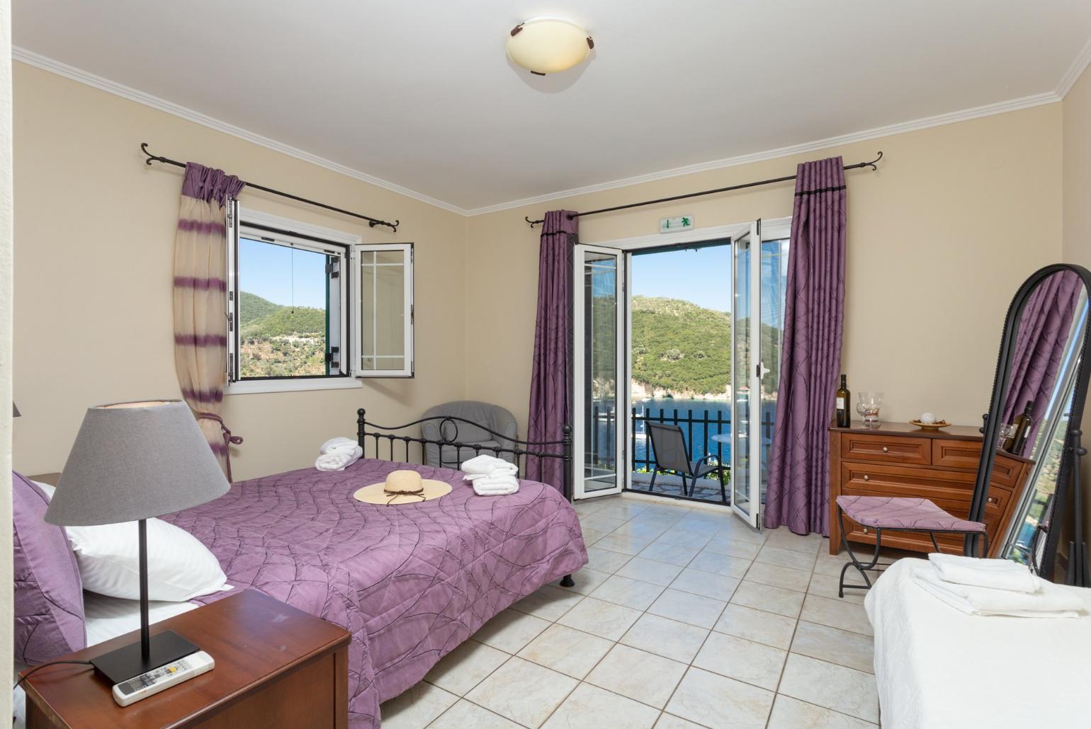 Double bedroom with extra single bed, en suite bathroom, AC, and terrace access with panoramic sea views