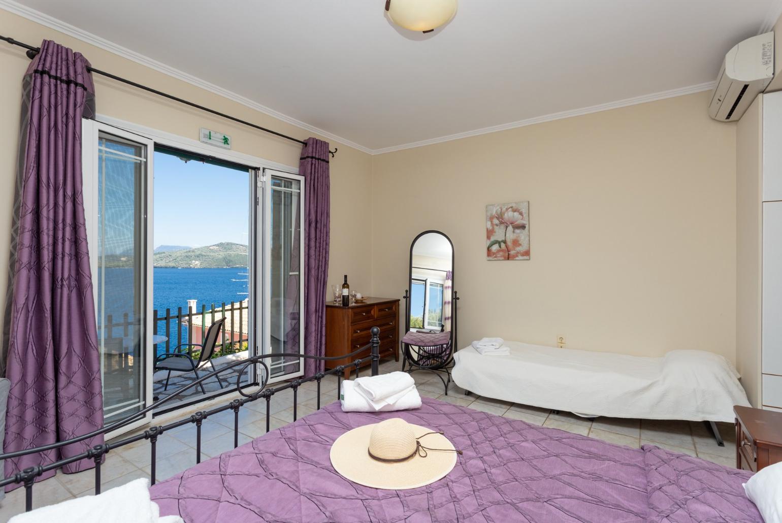 Double bedroom with extra single bed, en suite bathroom, AC, and terrace access with panoramic sea views