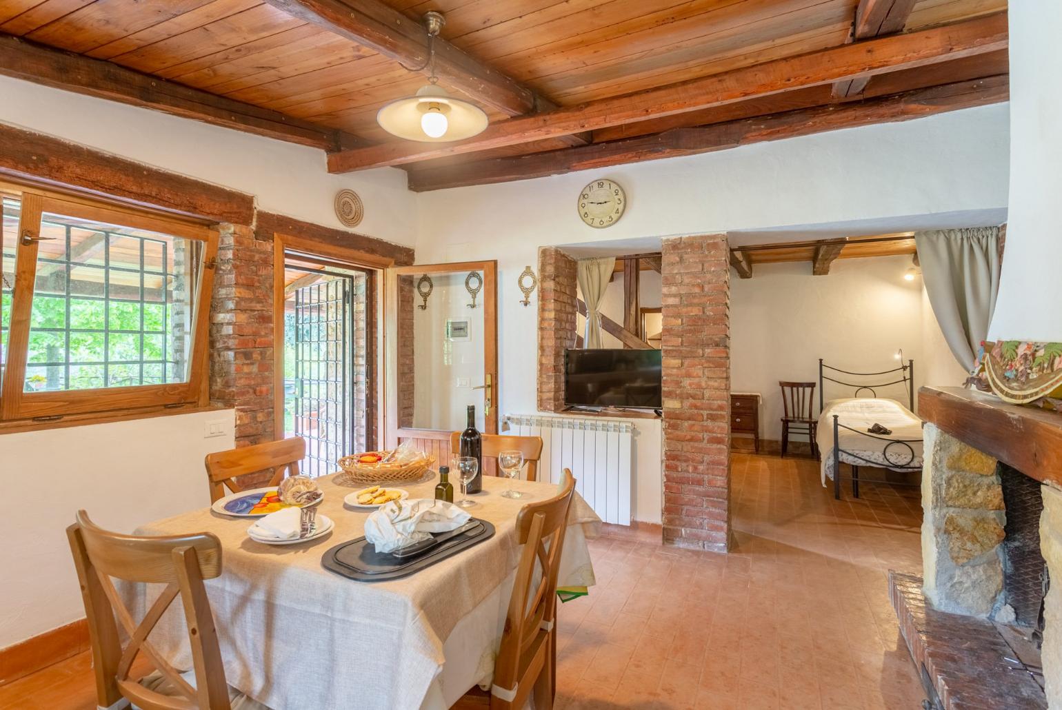 Open-plan living room with dining area, kitchen, ornamental fireplace, and terrace access