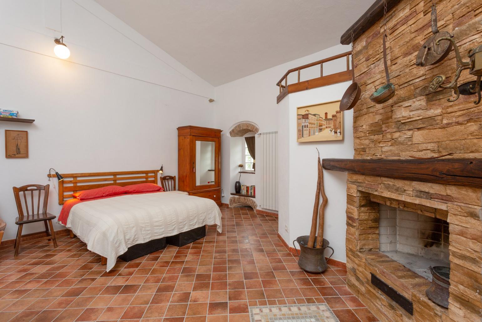 Open-plan room with double bed, dining area, sofa bed, kitchenette, and ornamental fireplace