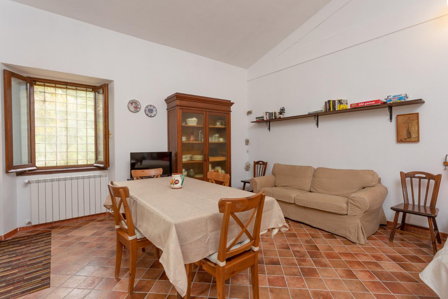 Open-plan room with double bed, dining area, sofa bed, kitchenette, and ornamental fireplace