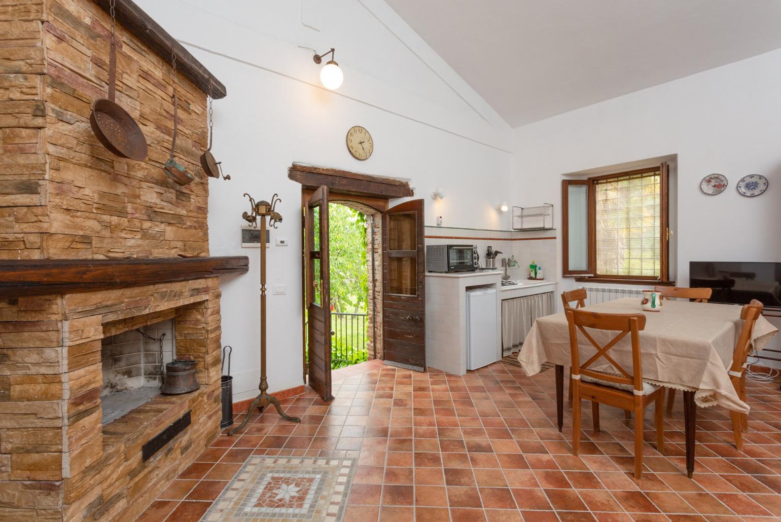 Open-plan room with double bed, dining area, sofa bed, kitchenette, and ornamental fireplace