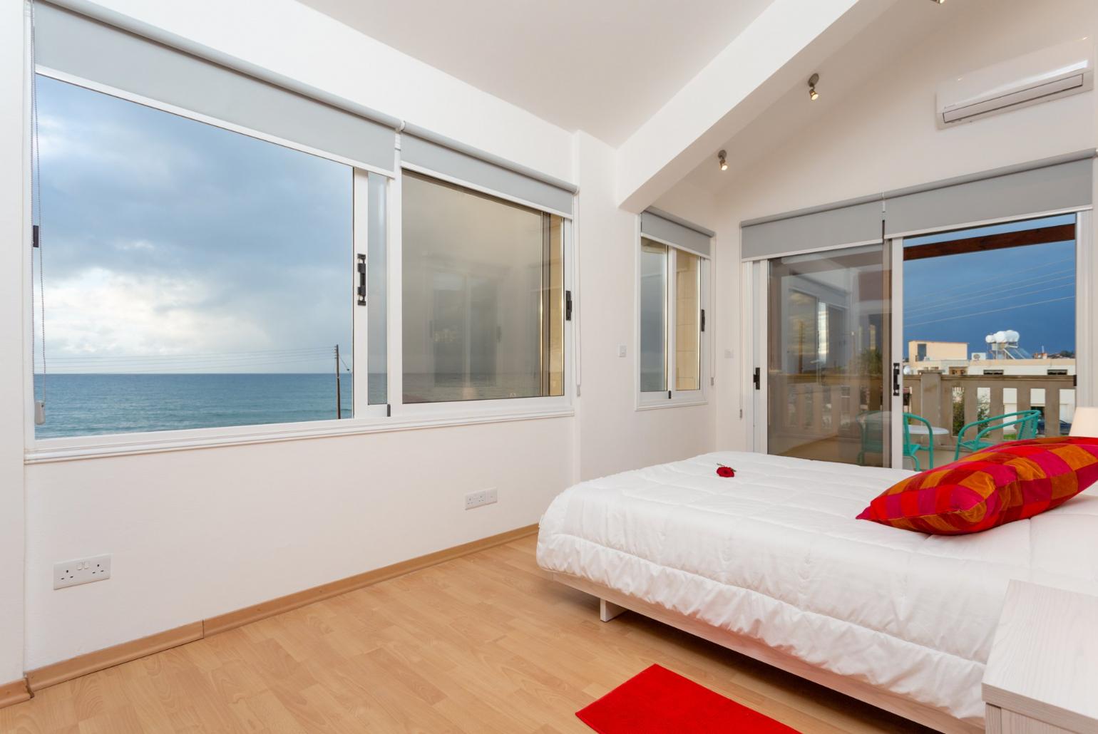 Double bedroom with en suite bathroom, A/C, panoramic sea views, and balcony access