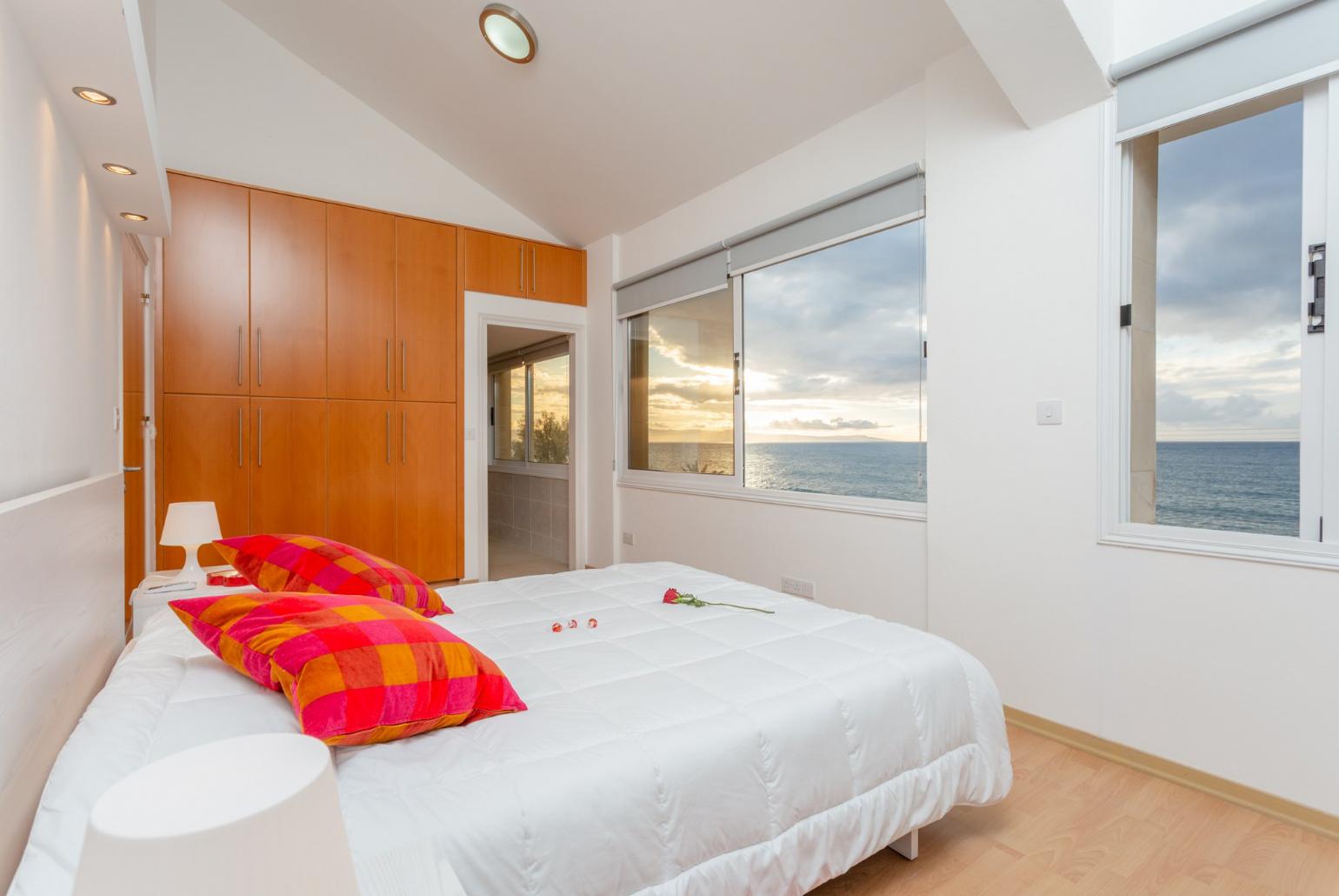 Double bedroom with en suite bathroom, A/C, panoramic sea views, and balcony access