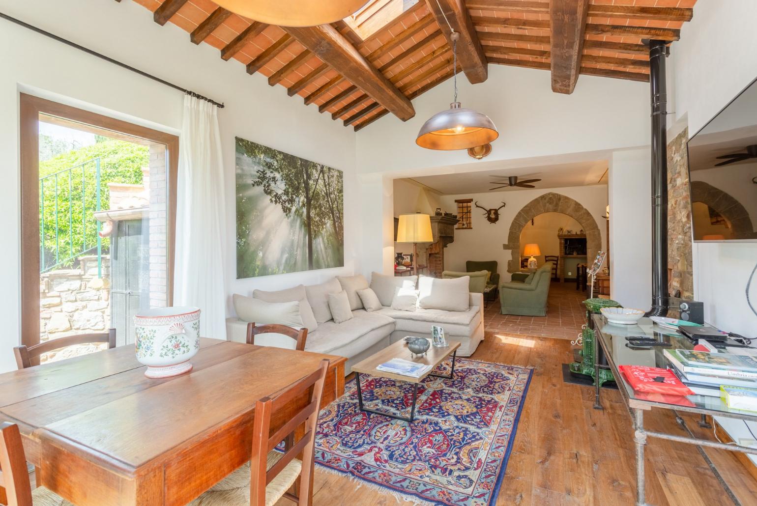 Living room on ground floor of main building with sofas, dining area, ornamental fireplaces, A/C, WiFi internet, satellite TVs, DVD player, and garden access 