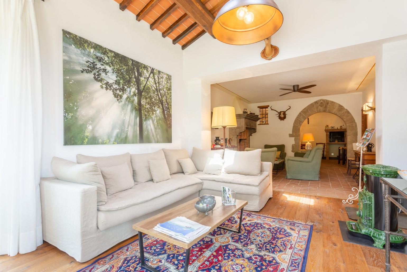 Living room on ground floor of main building with sofas, dining area, ornamental fireplaces, A/C, WiFi internet, satellite TVs, DVD player, and garden access 