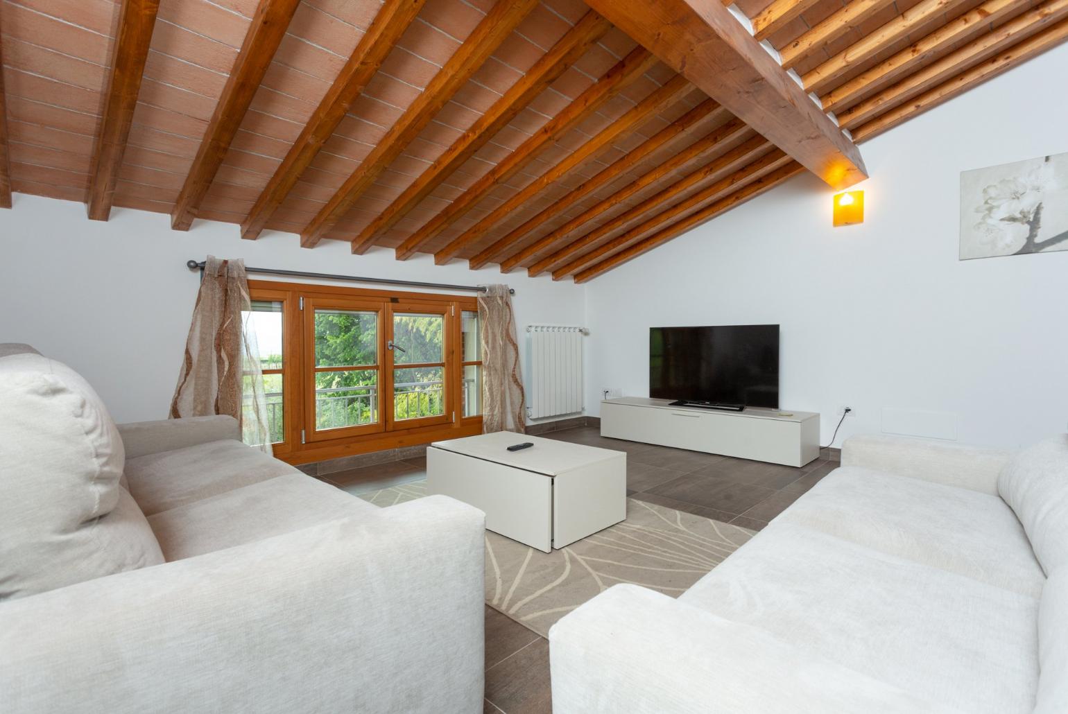 Living area on first floor with sofas and TV