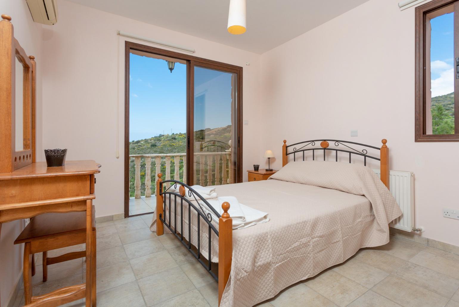 Double bedroom with en suite bathroom, A/C, and balcony access with views of sea and countryside