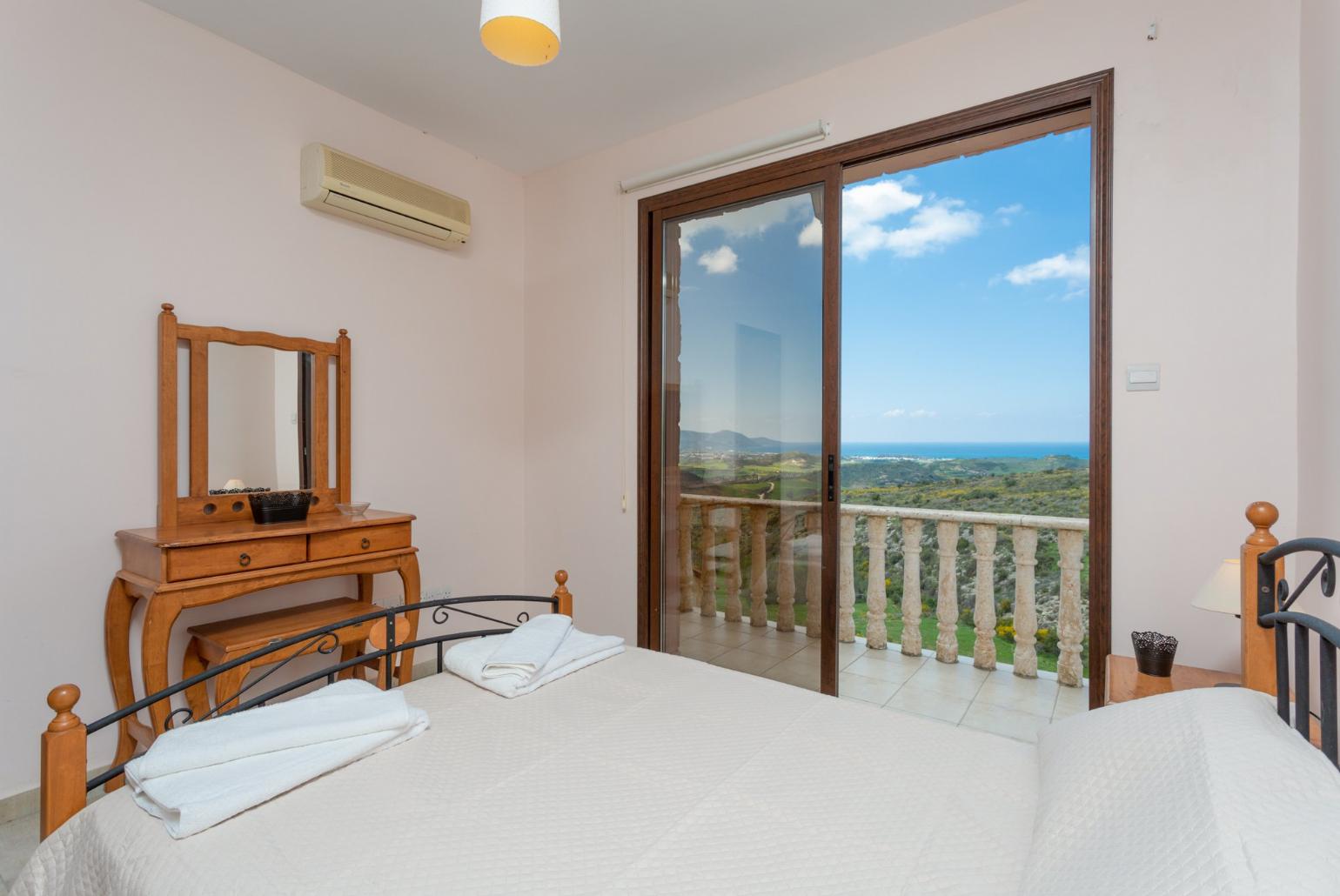 Double bedroom with en suite bathroom, A/C, and balcony access with views of sea and countryside