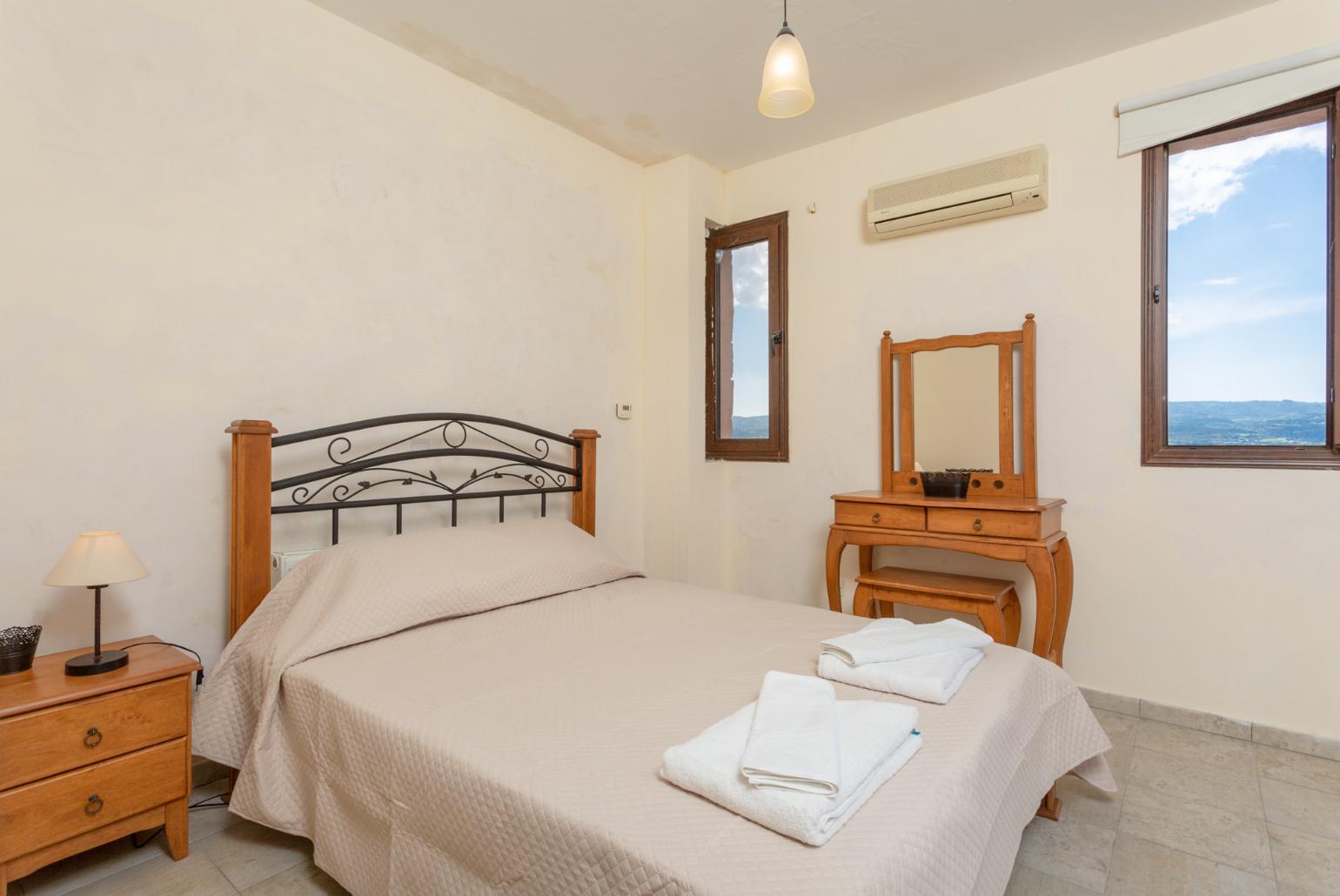 Double bedroom with en suite bathroom, A/C, and balcony access with panoramic views of the sea and countryside