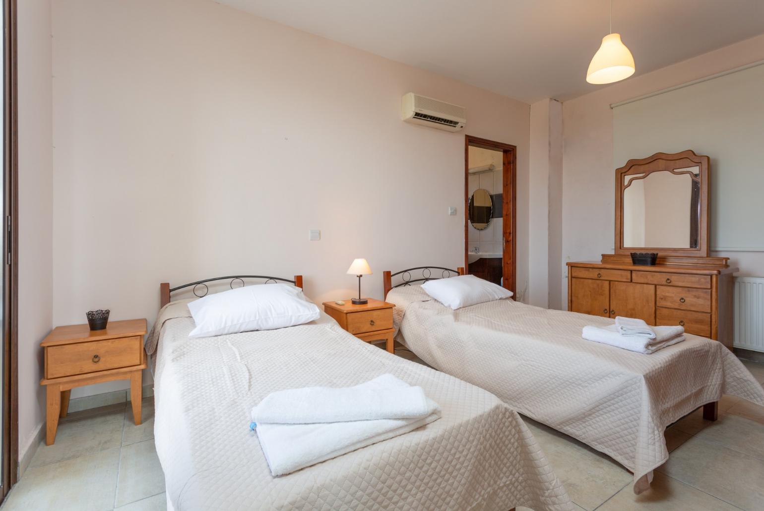 Twin bedroom with en suite bathroom, A/C, and terrace access with panoramic views of the sea and countryside