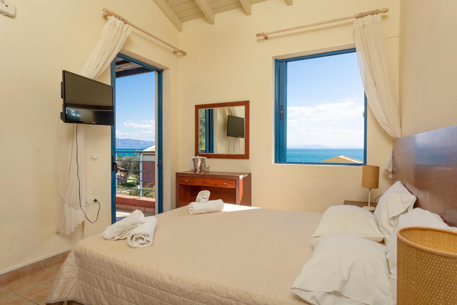 Double bedroom with A/C, TV, and balcony access with sea views