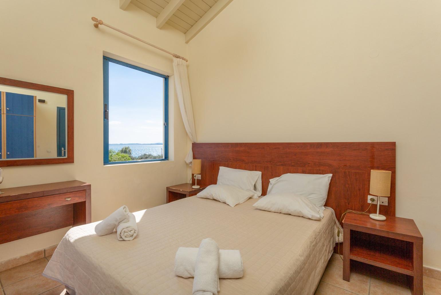 Double bedroom with A/C, TV, and balcony access with sea views