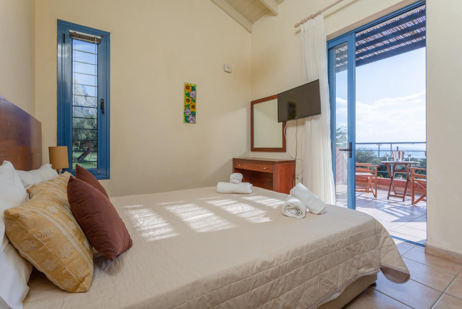 Double bedroom with A/C, TV, and balcony access with sea views