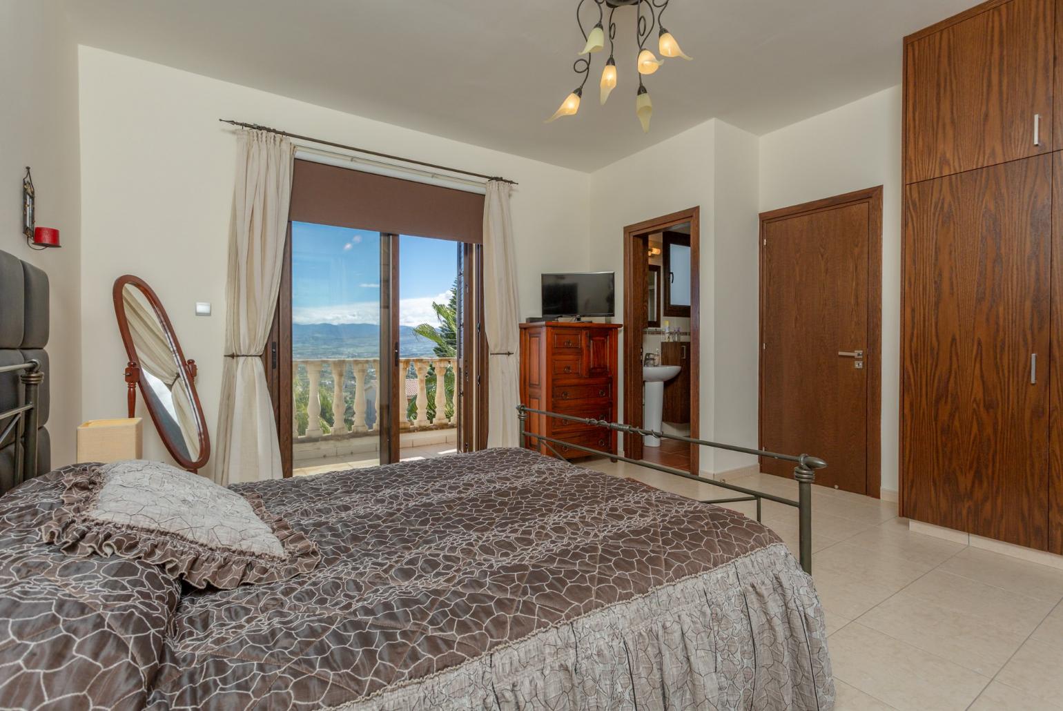 Double bedroom with en suite bathroom, A/C, TV, and balcony access with sea views
