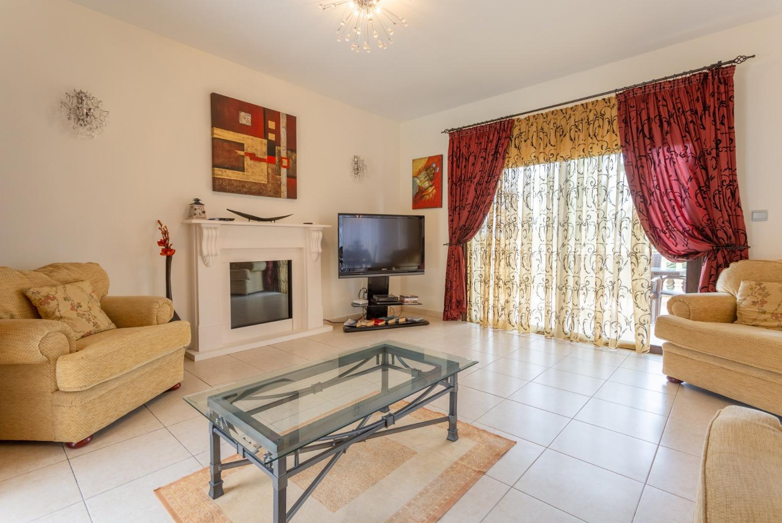 Living room with sofas, ornamental fireplace, A/C, WiFi internet, satellite TV, DVD player, and pool terrace and balcony access