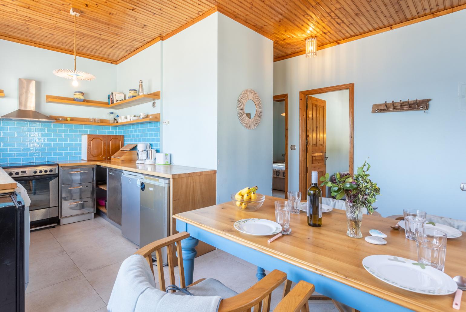 Open-plan living room with dining area, kitchen, sea views, and balcony access