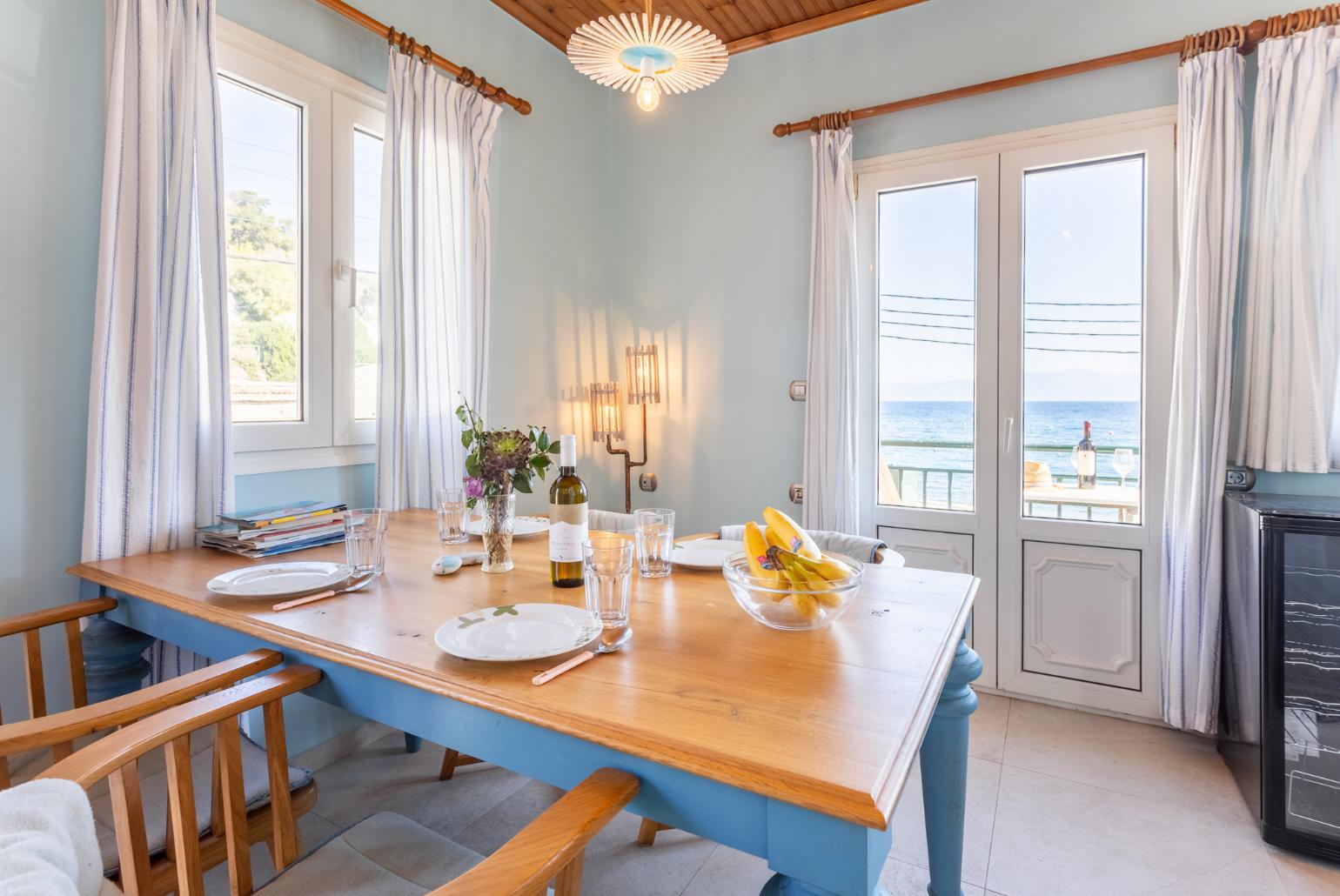 Open-plan living room with dining area, kitchen, sea views, and balcony access