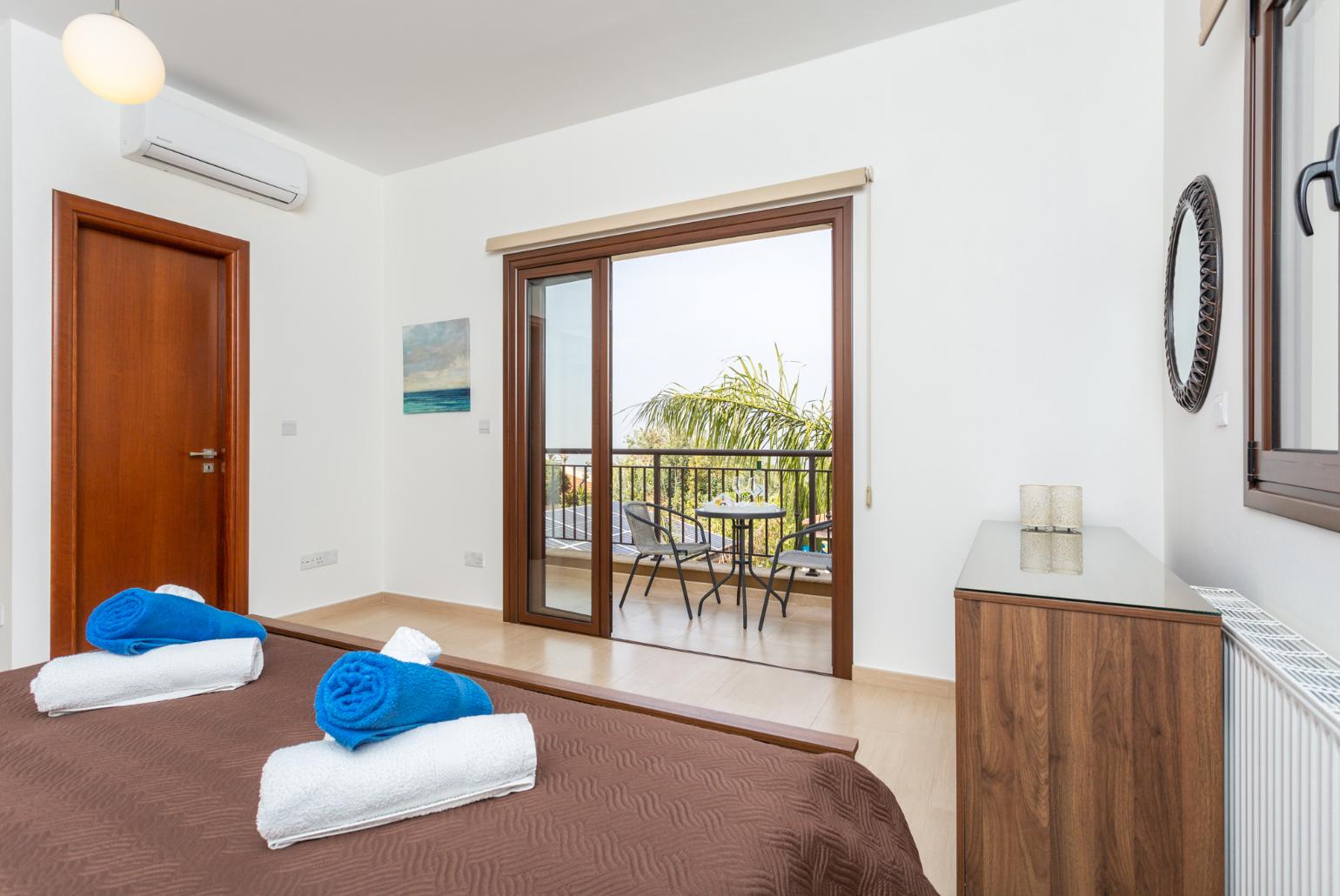 Double bedroom with en suite bathroom, A/C, and balcony access