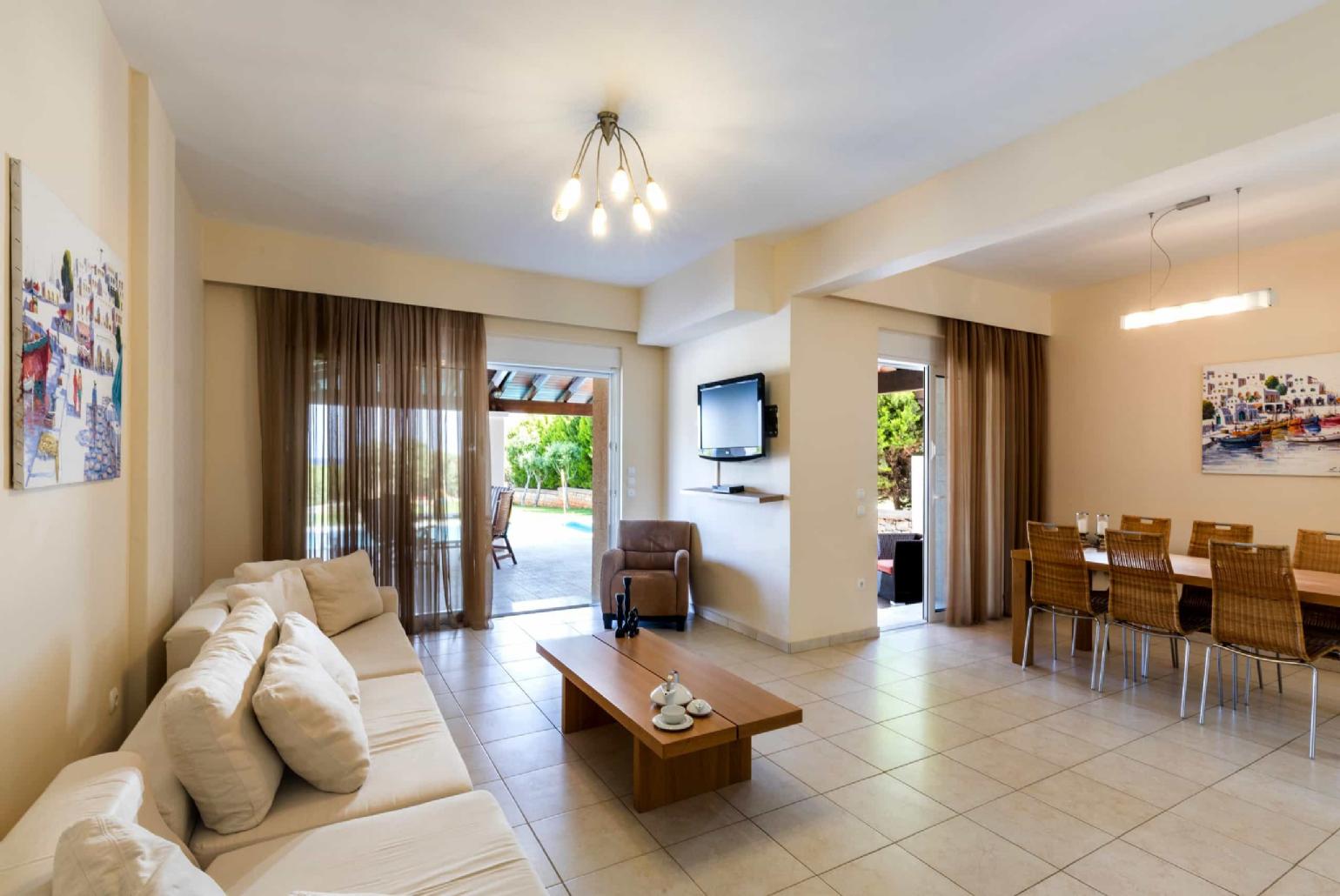 Open plan living room with TV and indoor dining 