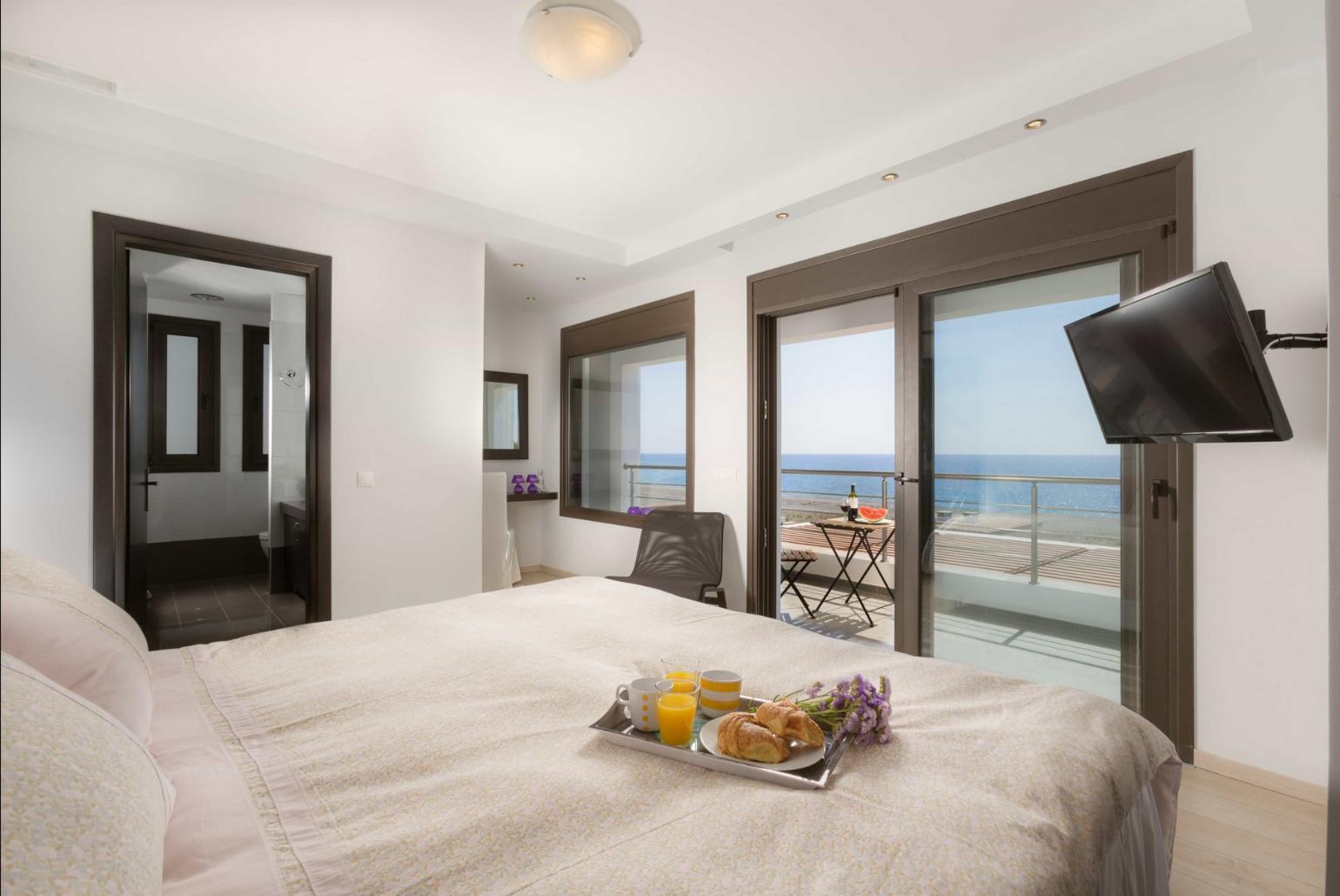 Double bedroom with en suite bathroom, A/C, TV, and balcony with panoramic sea views