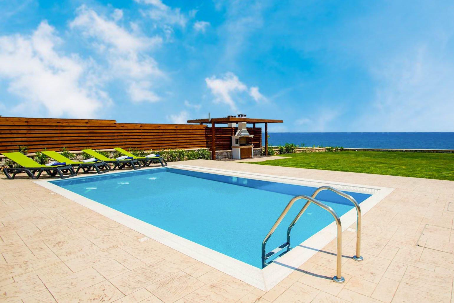 Private pool, terrace, and lawn with panoramic sea views