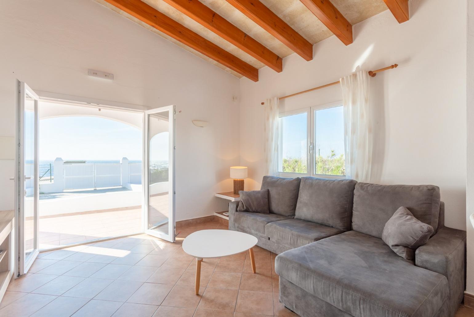 Living room with sofa, dining area, ornamental fireplace, WiFi internet, satellite TV, DVD player, and terrace access with sea views