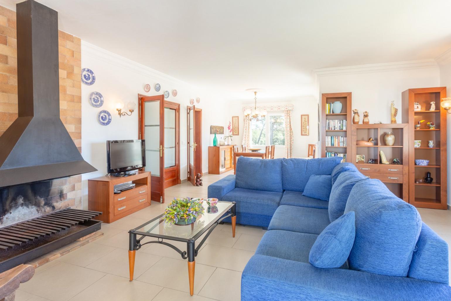 Living room with sofas, dining area, ornamental fireplace, WiFi internet, satellite TV, DVD player, and balcony access