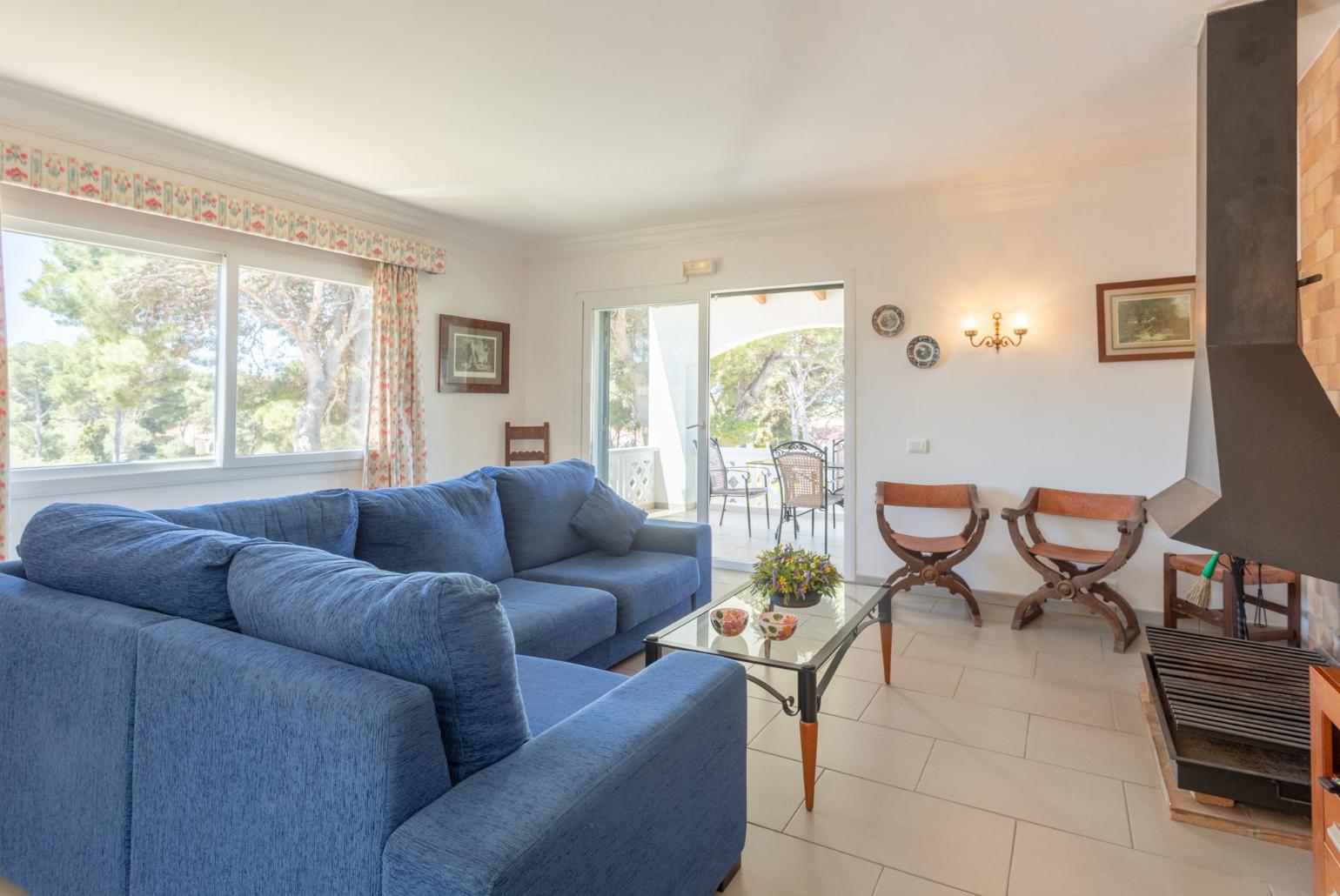 Living room with sofas, dining area, ornamental fireplace, WiFi internet, satellite TV, DVD player, and balcony access