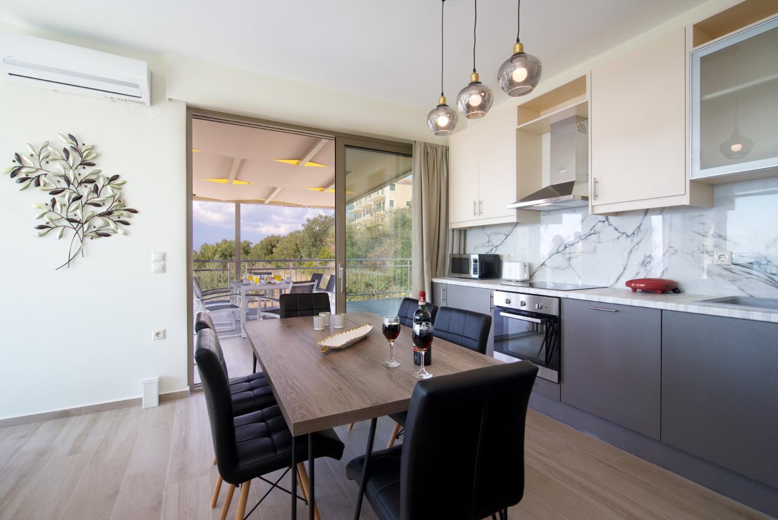 Equipped kitchen with dining area and terrace access