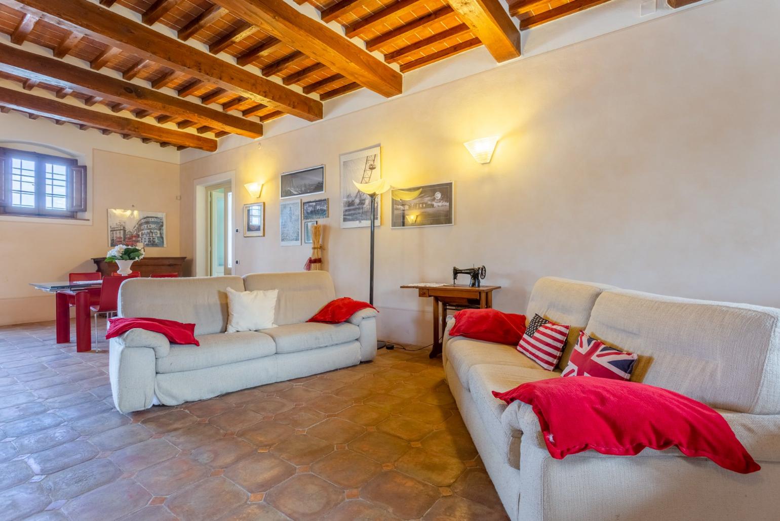 Living room with sofas, dining area, ornamental fireplace, piano, foosball table, WiFi internet, satellite TV, DVD player, and terrace access