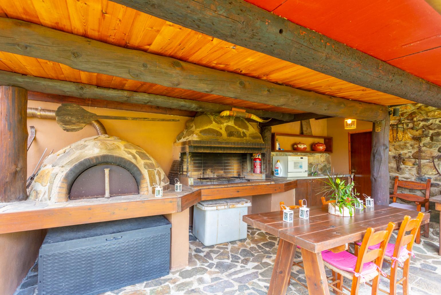 Sheltered terrace area with BBQ and wood-fired oven