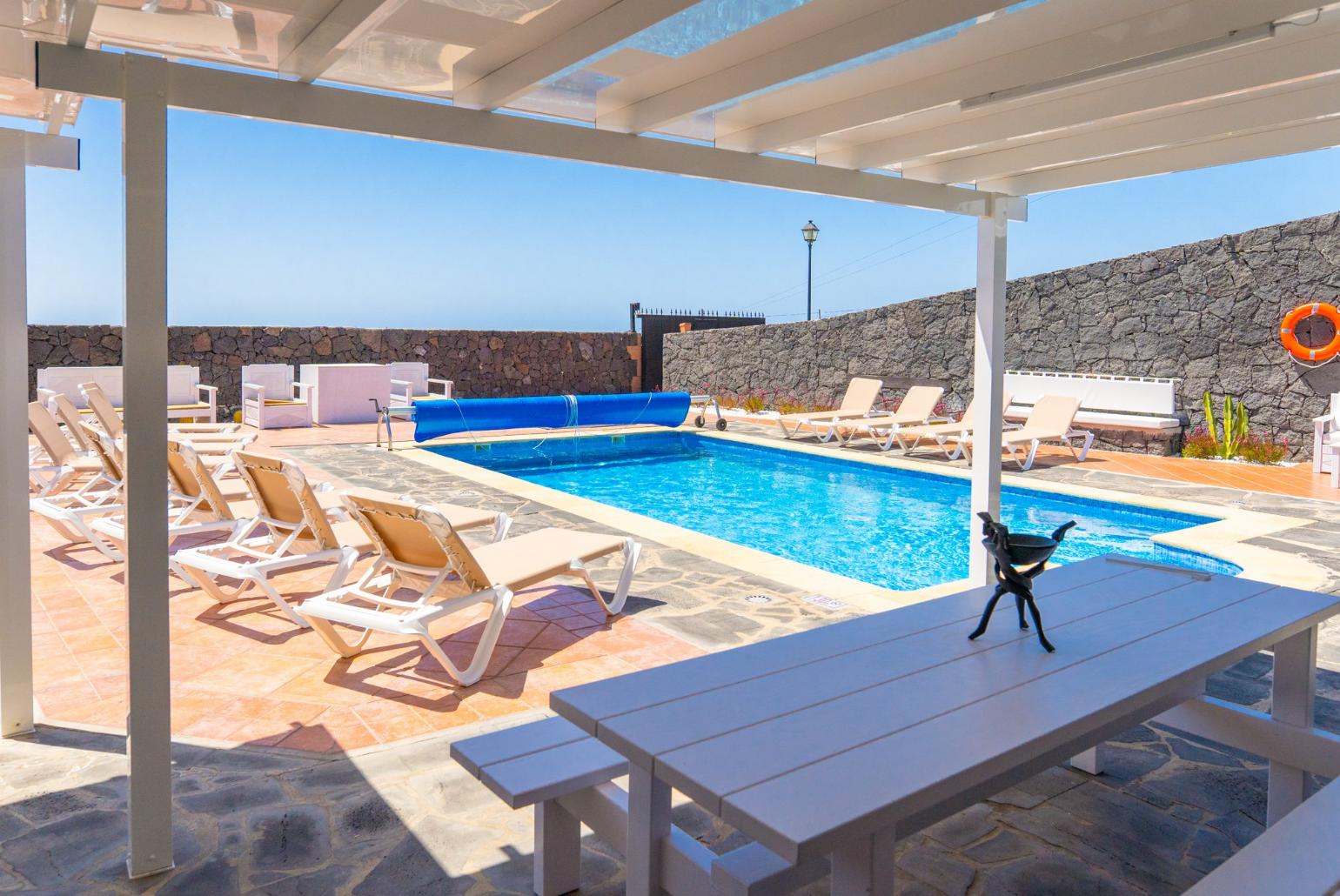 Pool area with sunbeds,sheltered dining area and outdoor BBQ