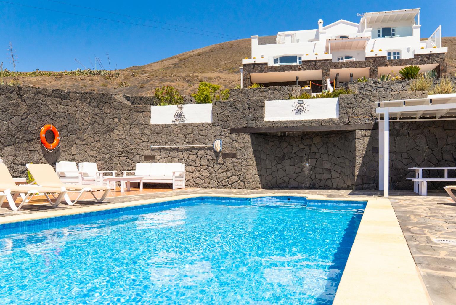 Pool area with sunbeds,sheltered dining area and outdoor BBQ