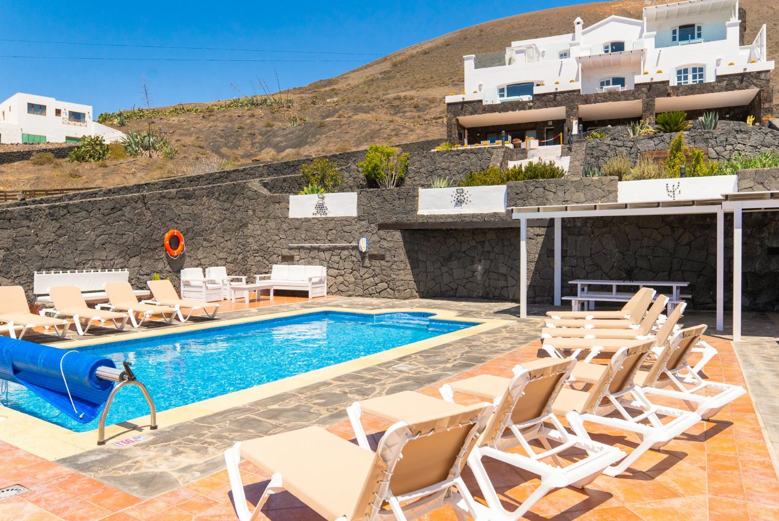 Pool area with sunbeds,sheltered dining area and outdoor BBQ